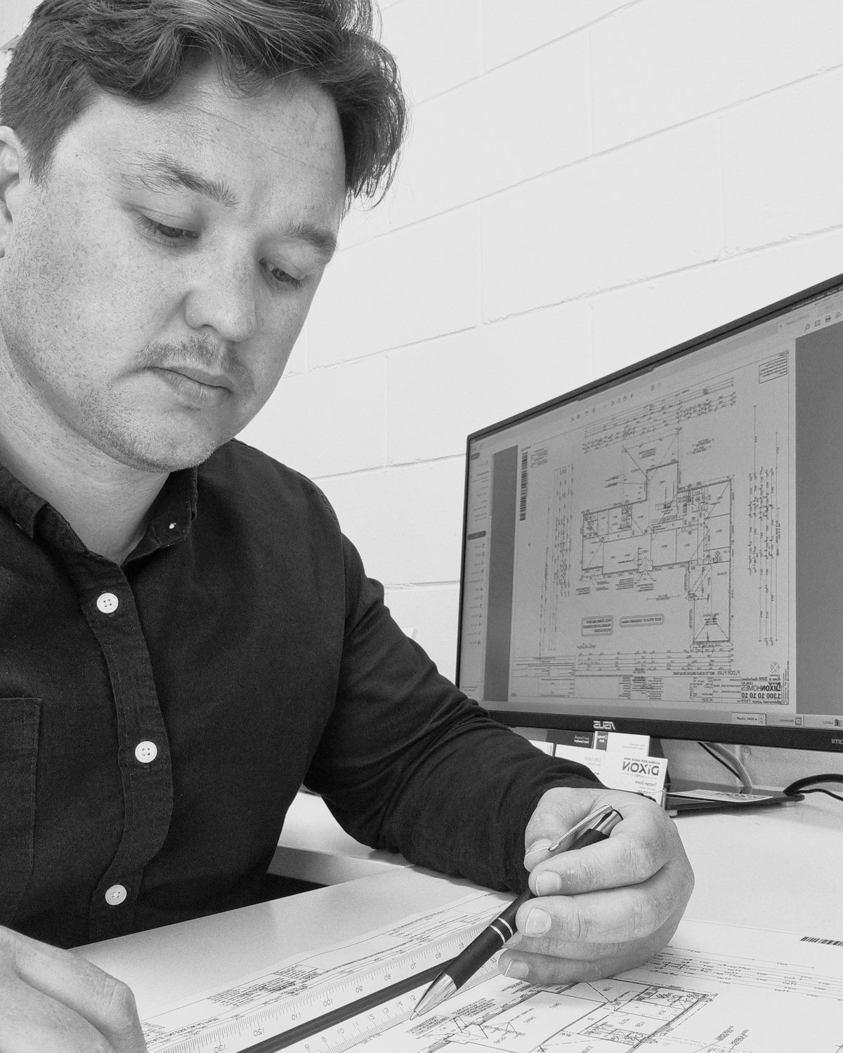 Eddy’s founder marking up a printed floor plan at his desk